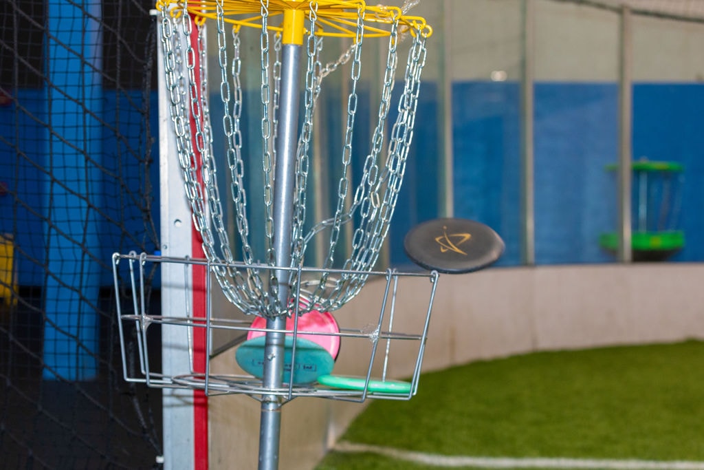 Disc golf basket with colorful discs