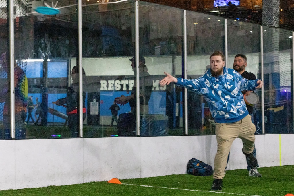 Player throwing frisbee at indoor IDGX event